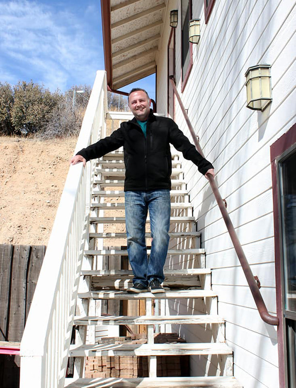 Portrait of Jared Wockenfuss standing on outdoor stairs